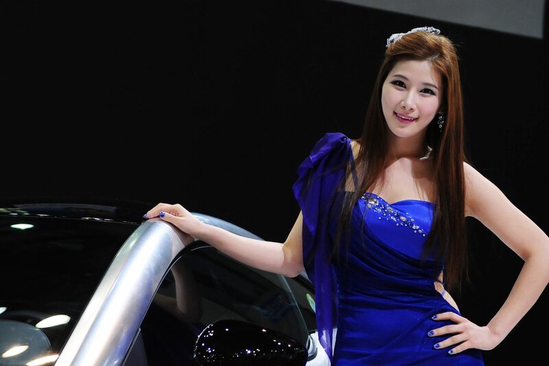 Woman in blue dress at car show