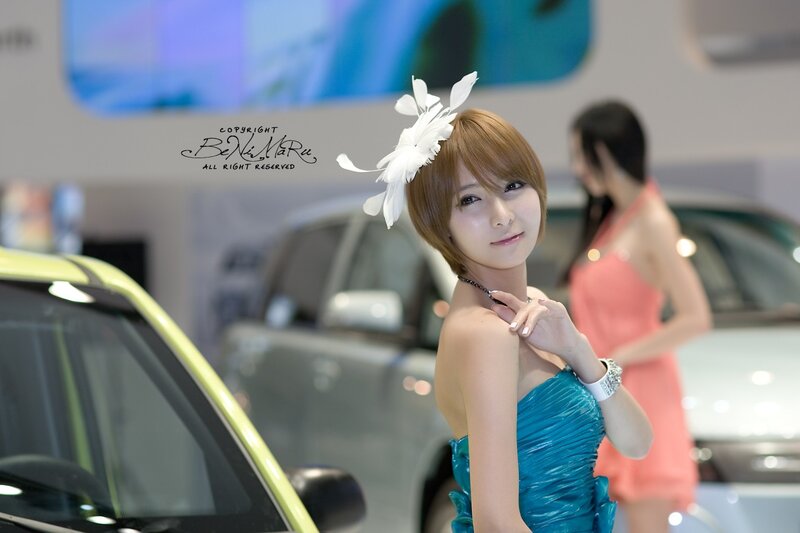Woman in blue dress at car show