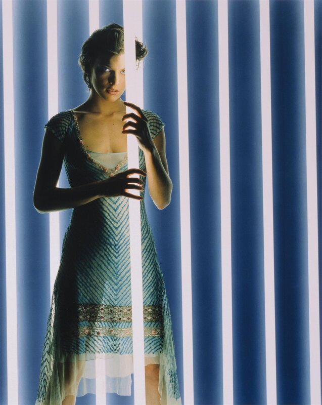 woman in blue dress behind bars