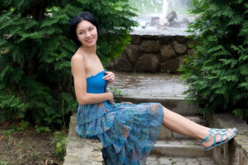 Woman in blue dress by fountain