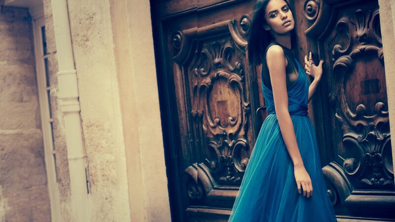 woman in blue dress by ornate door