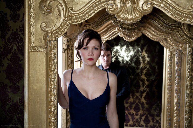 Woman in blue dress by ornate mirror