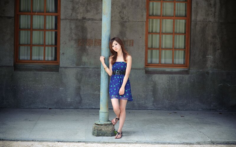 Woman in blue dress by pole