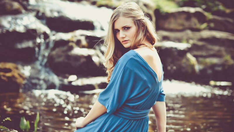 woman in blue dress by stream