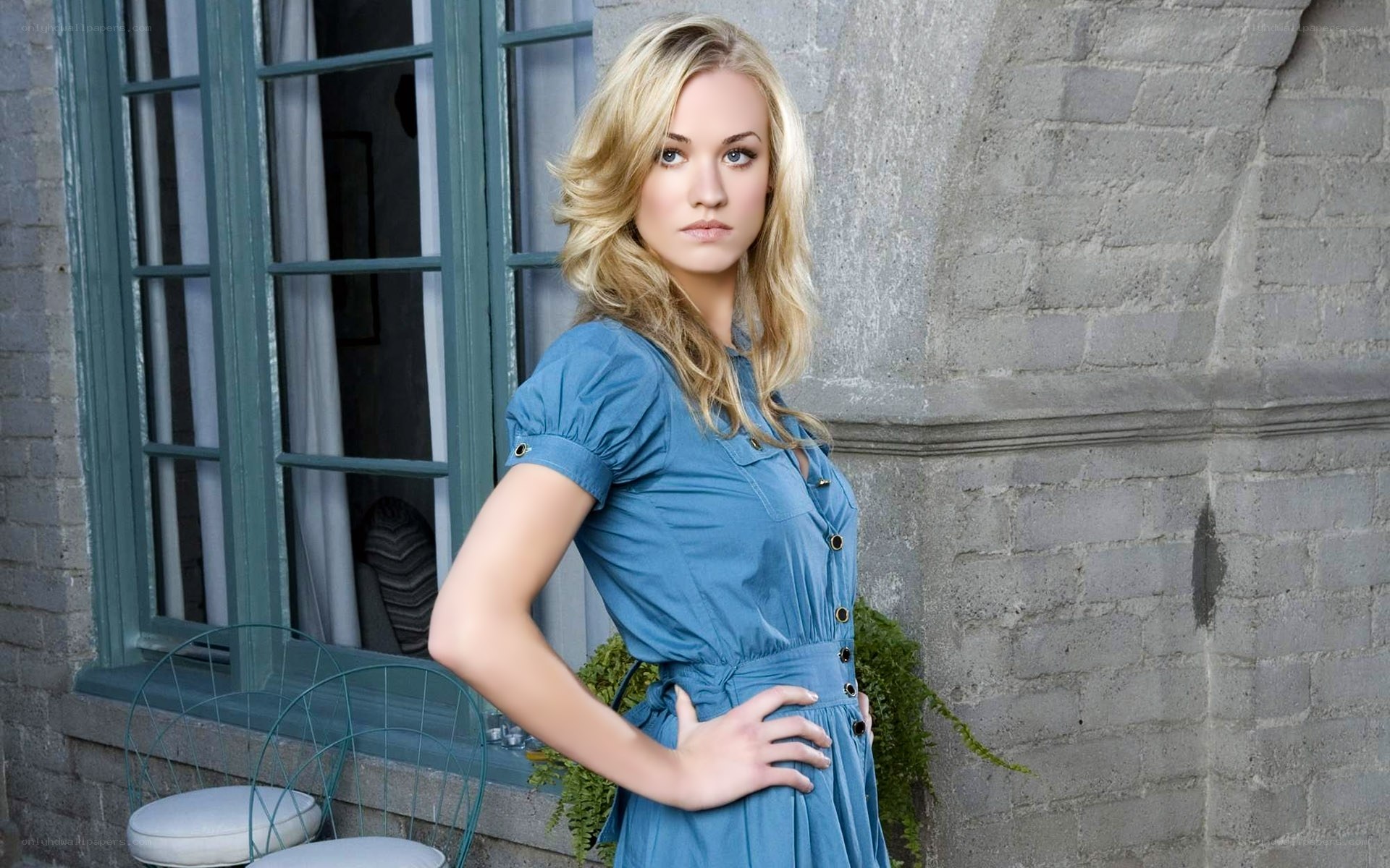 woman in blue dress by window