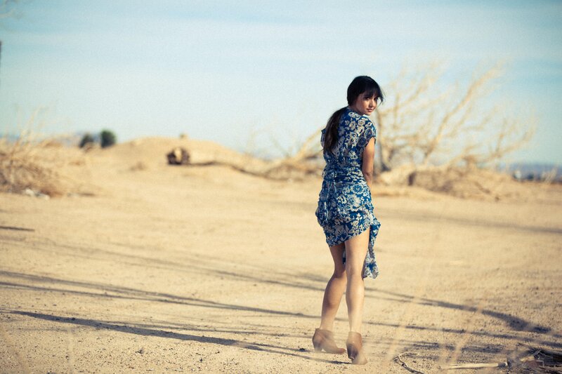 woman in blue dress on dirt road