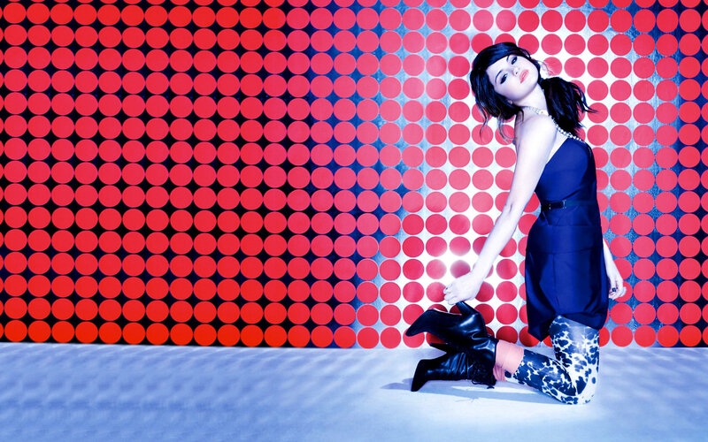 woman in blue dress on patterned wall