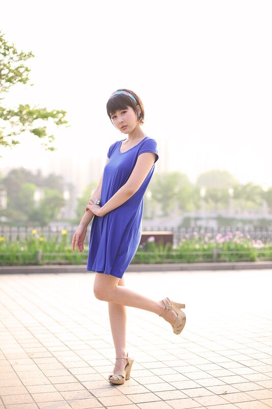Woman in blue dress posing outdoors