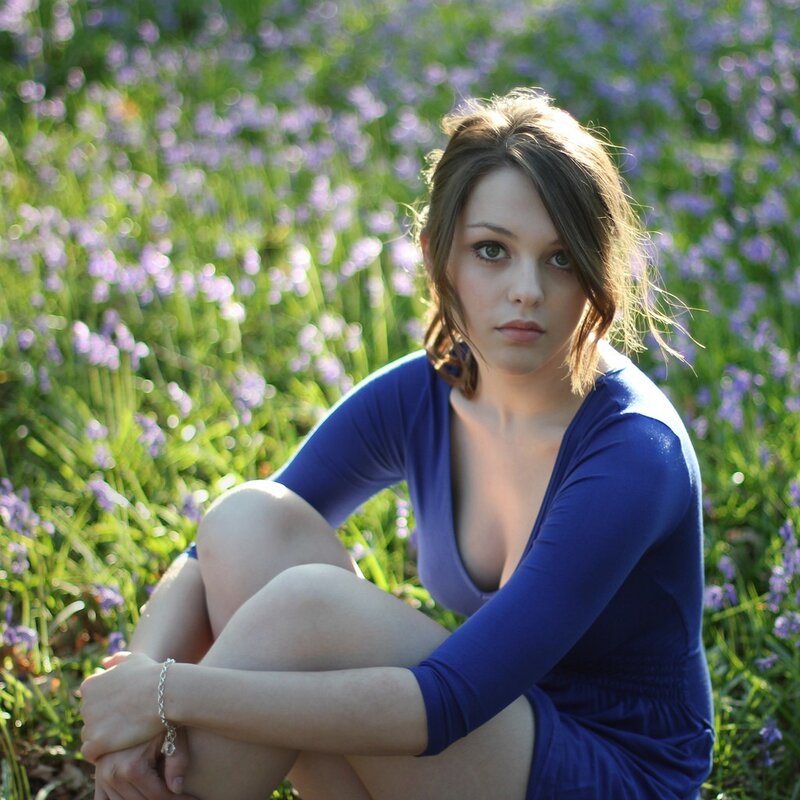 woman in blue dress sitting in field