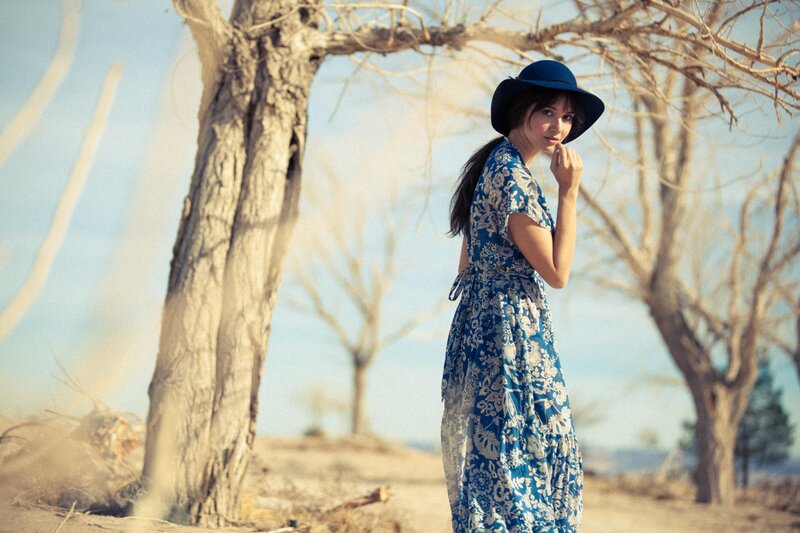 Woman in blue dress under trees