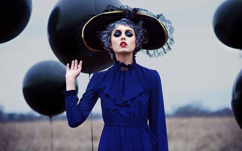 woman in blue dress with black balloons