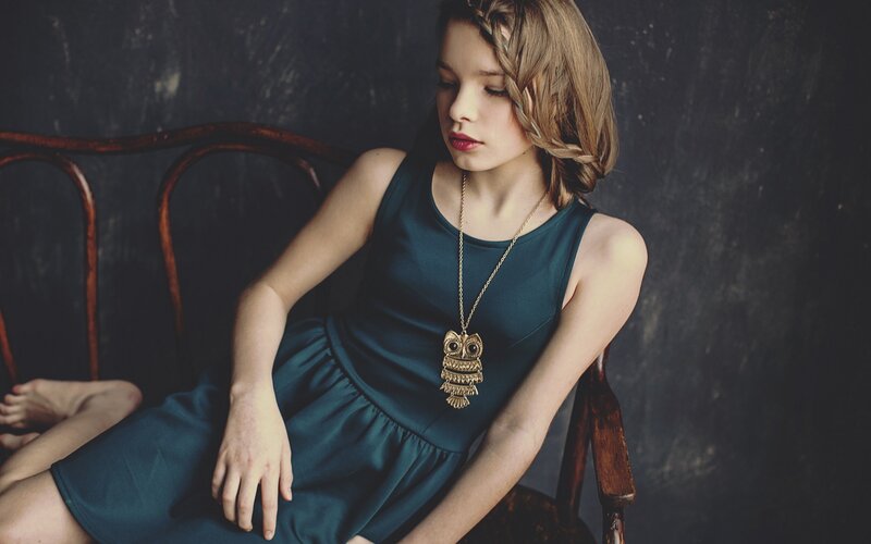 woman in blue dress with owl necklace