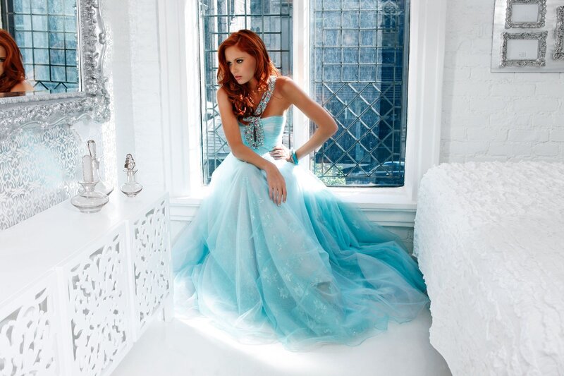 Woman in blue gown by window