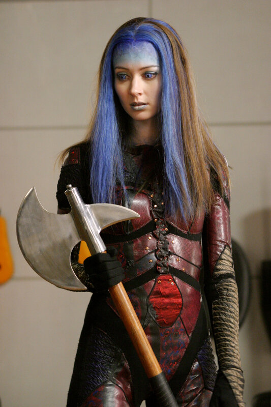 woman in blue-haired costume with axe