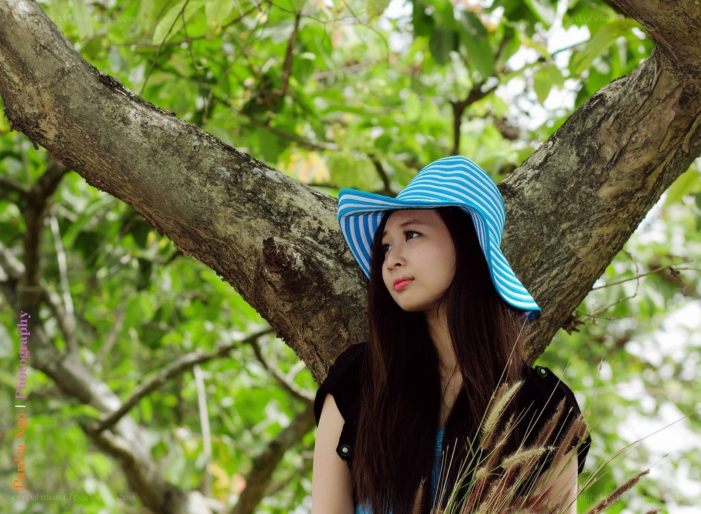 woman in blue hat under tree