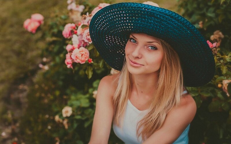 woman in blue hat with roses