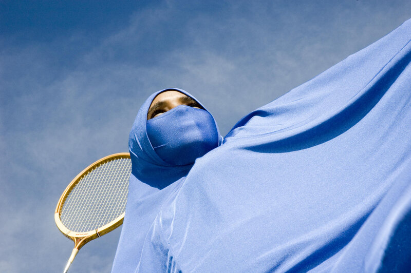 woman in blue hijab with racket