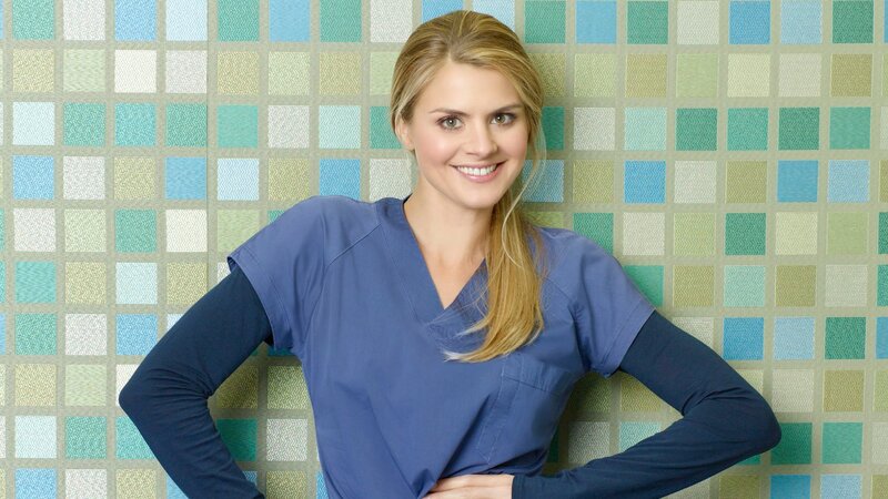 woman in blue scrubs smiling