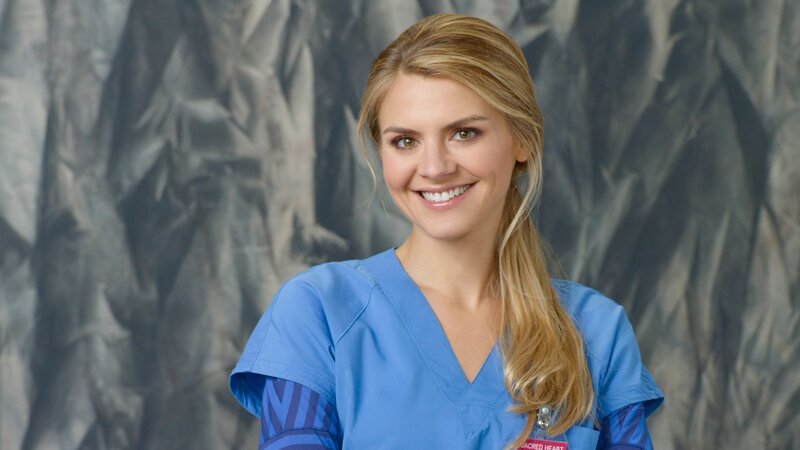 woman in blue scrubs smiling