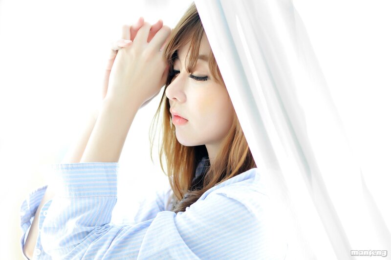 woman in blue shirt by window
