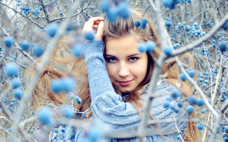 woman in blue sweater among berries