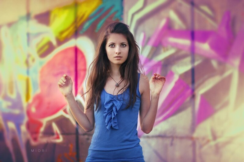 woman in blue top against graffiti