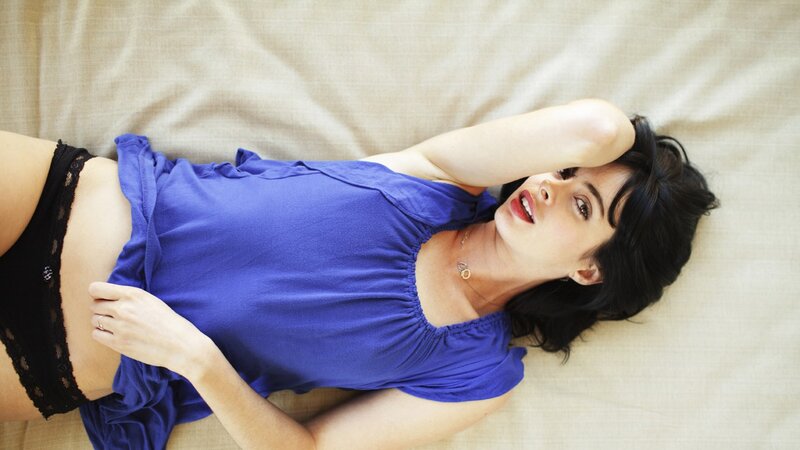 woman in blue top lying on bed