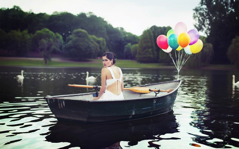 Woman in boat with balloons
