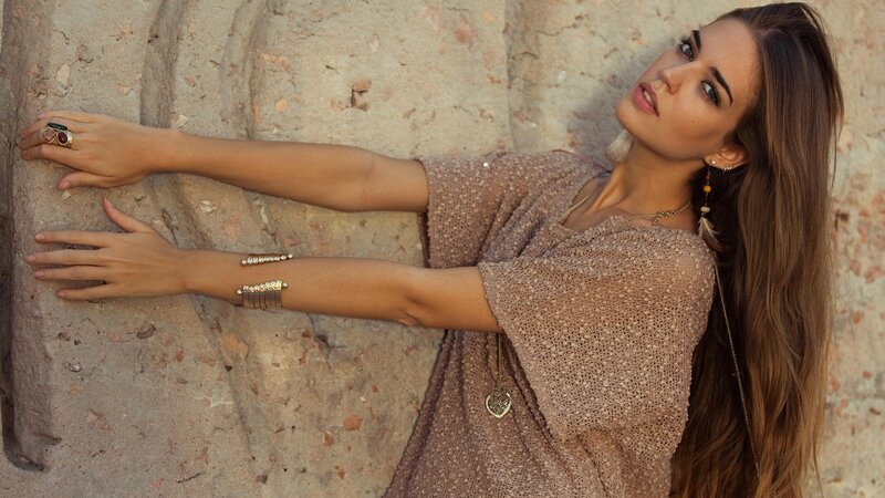 woman in boho dress leaning on wall