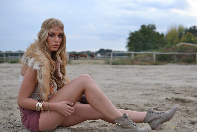 woman in boho style sitting on sand