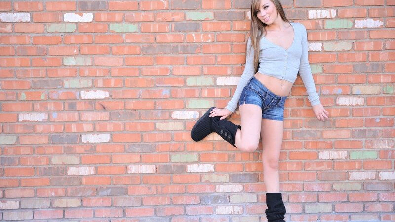 woman in boots against brick wall