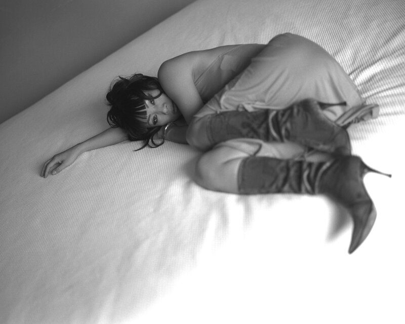 woman in boots on bed