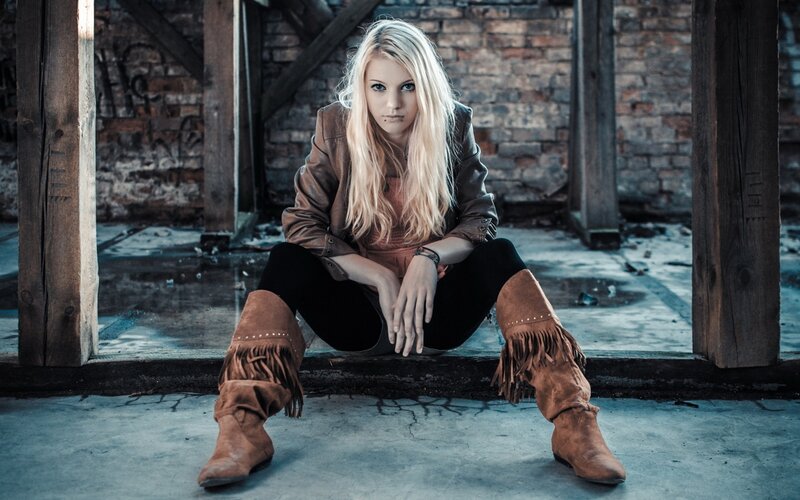 woman in boots sitting on step