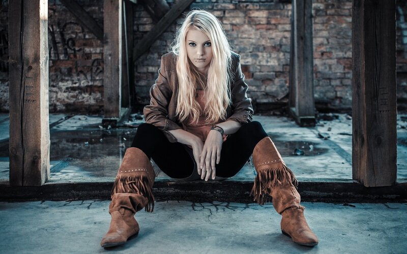 woman in boots sitting on steps