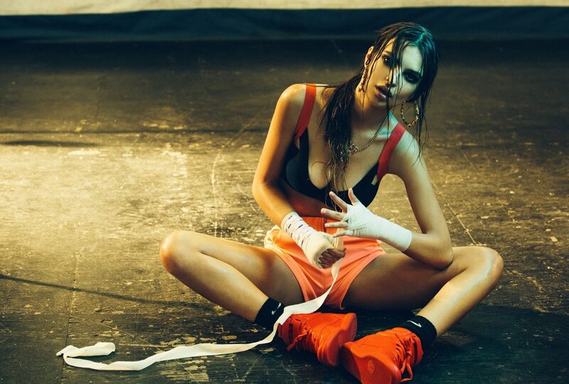 woman in boxing gear sitting on floor