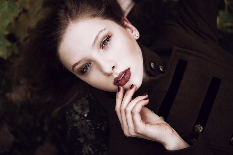 woman in brown coat lying down