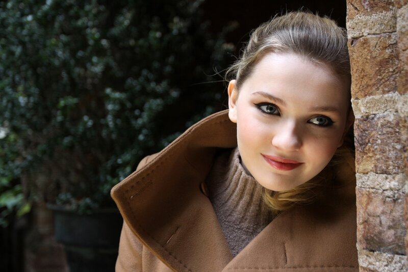 woman in brown coat smiling