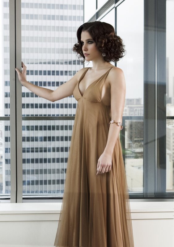 woman in brown dress by window