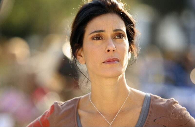 woman in brown shirt looking away
