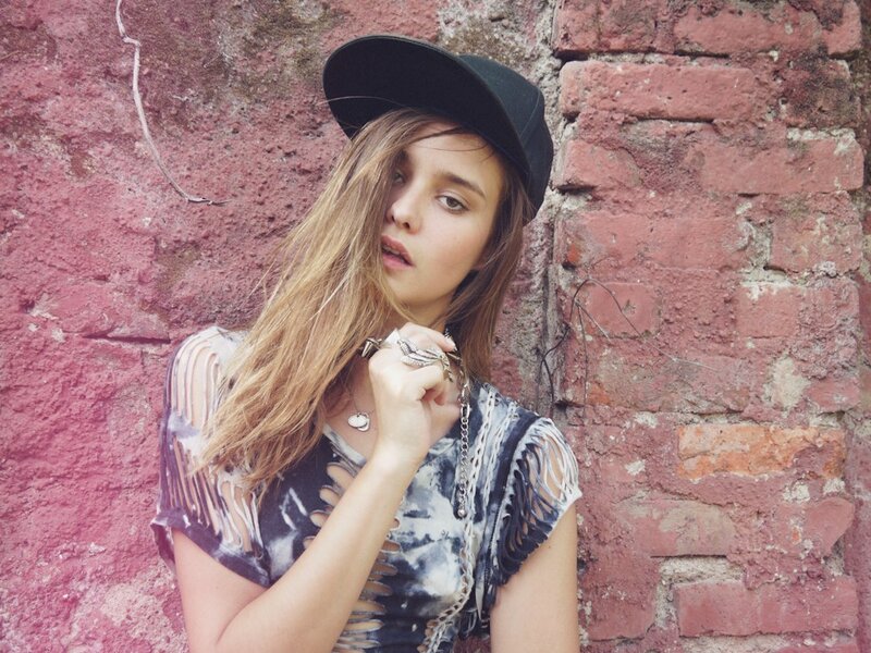 woman in cap against brick wall
