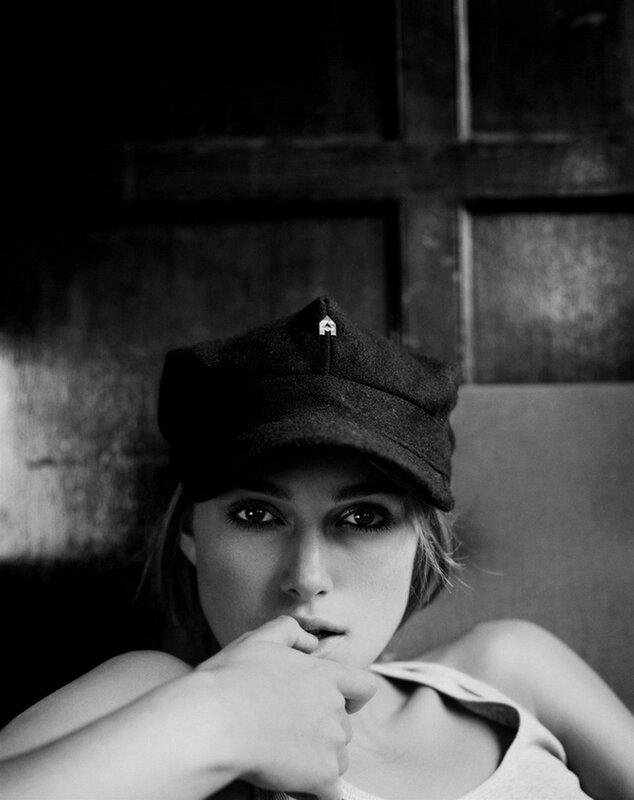 woman in cap with hand on chin