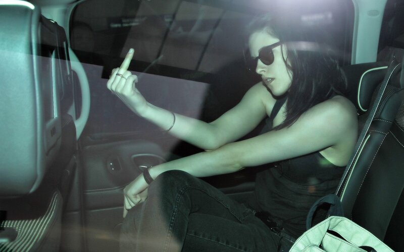 woman in car making hand gesture