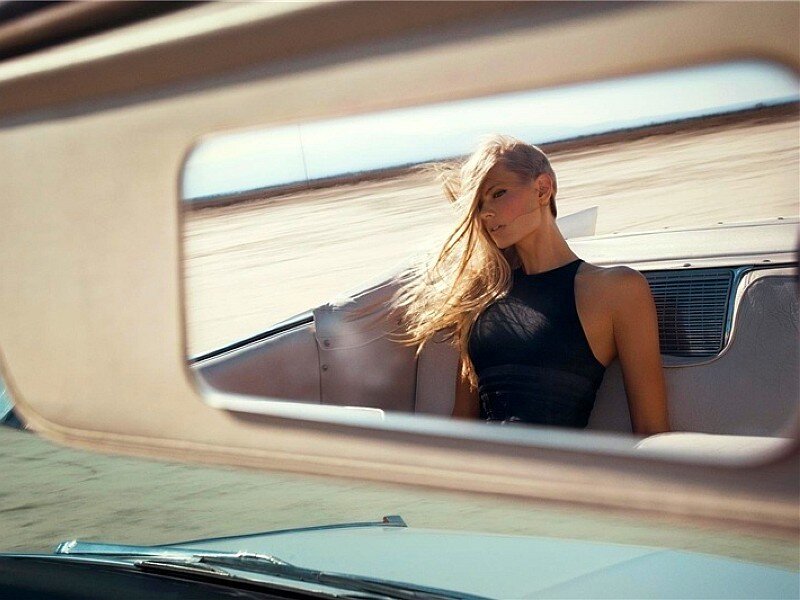 woman in car on desert road