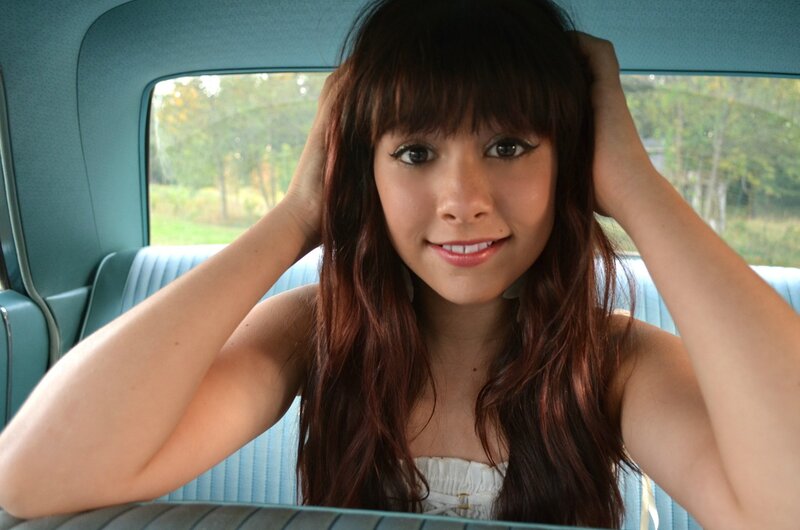 woman in car with hands on head