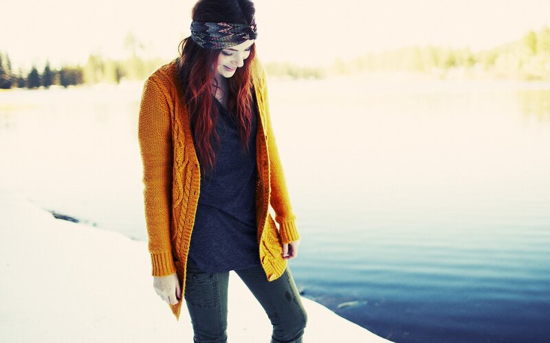 woman in cardigan by lake