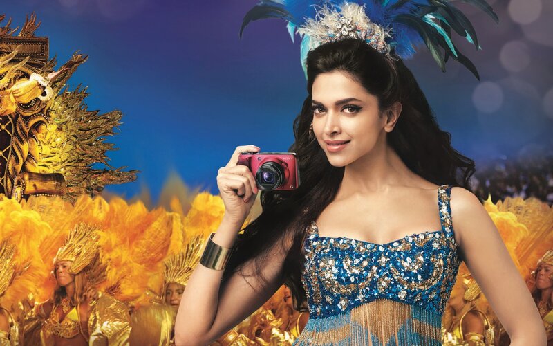woman in carnival costume holding camera