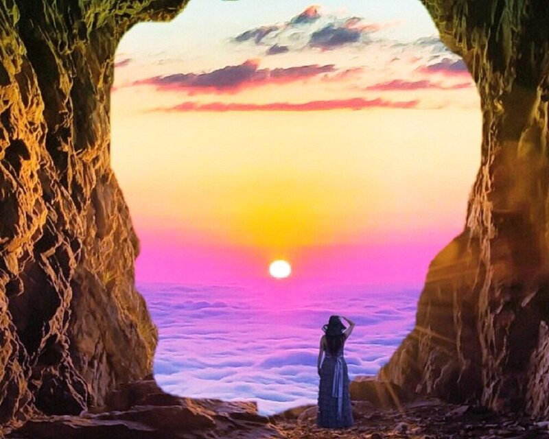 Woman in Cave Watching Sunset