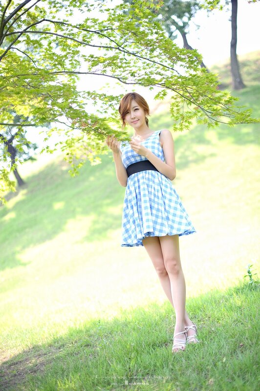Woman in checkered dress under tree