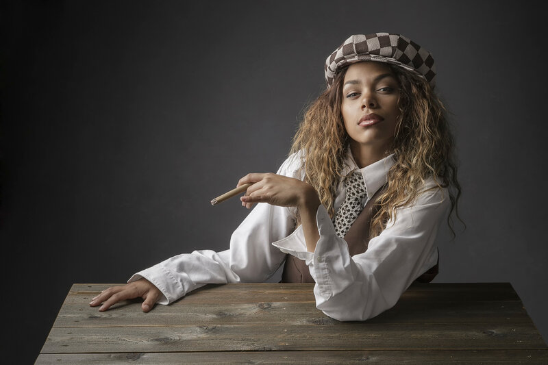 woman in checkered hat holding cigar
