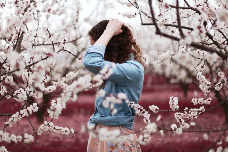 woman in cherry blossom garden